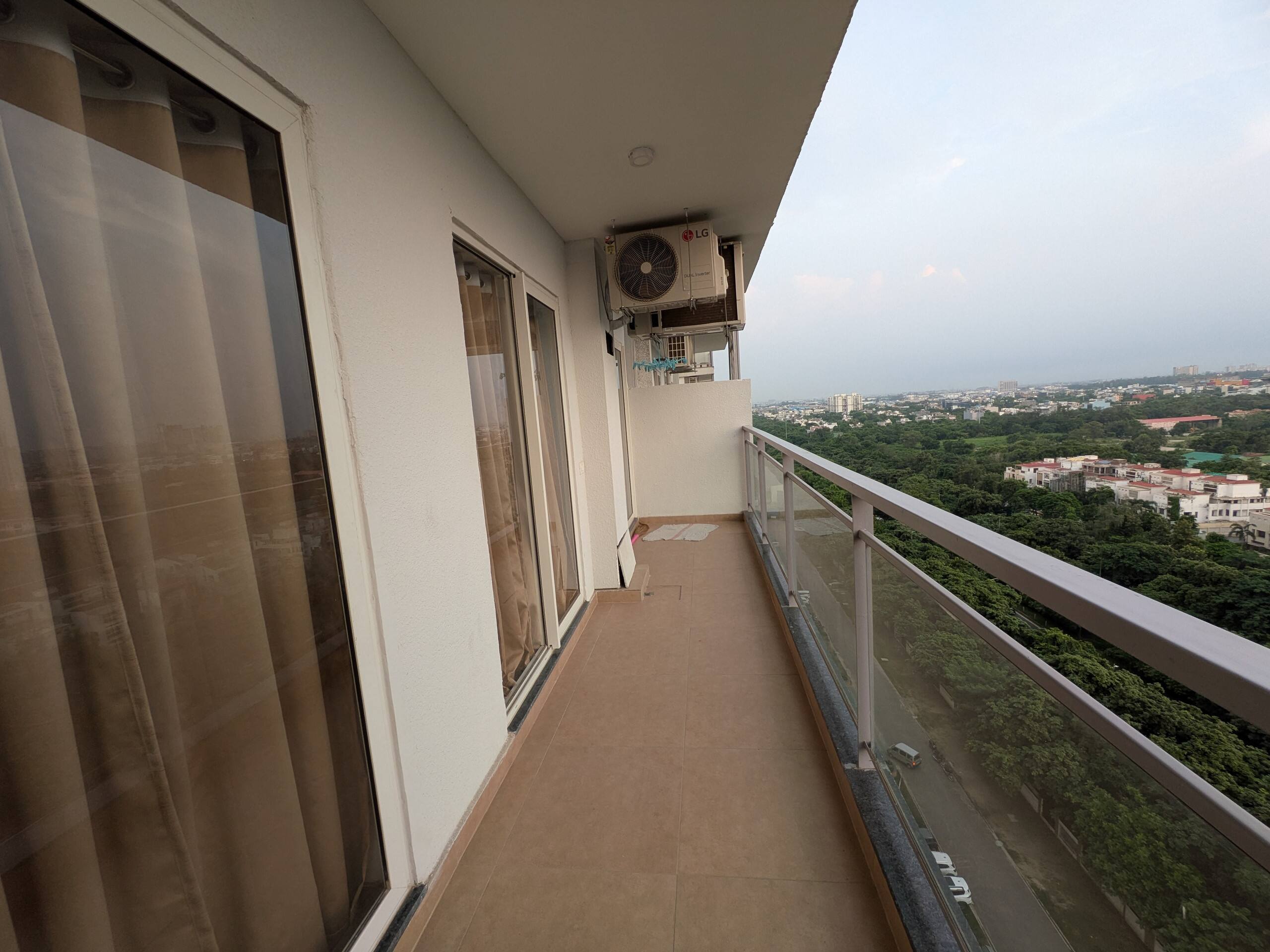 Long balcony with glass railing and green views