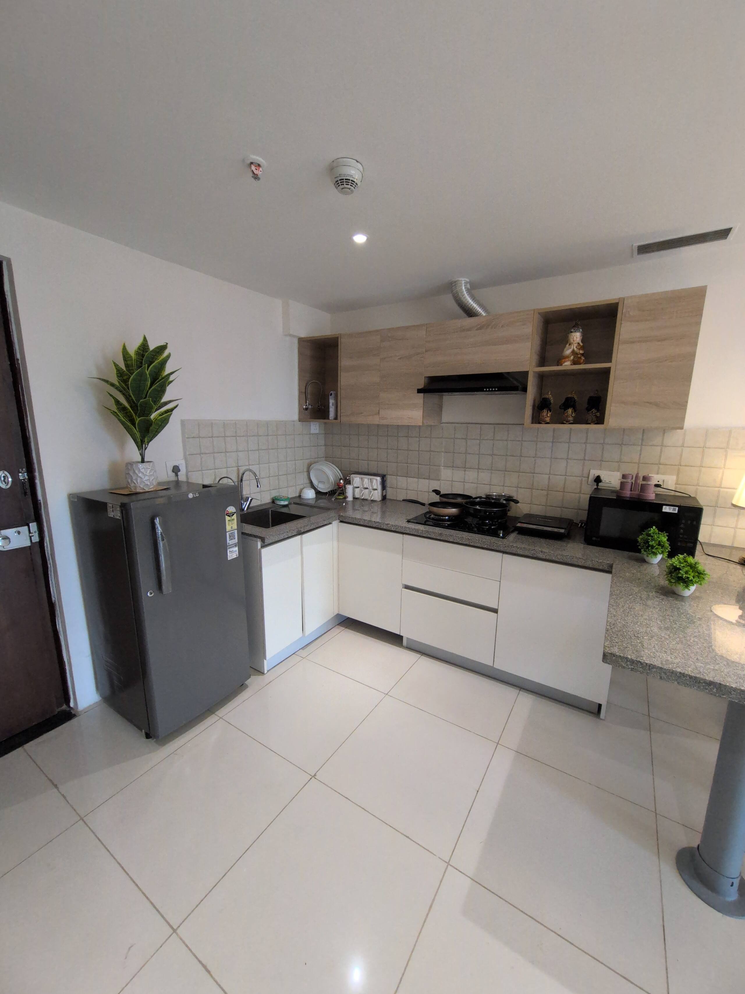 Kitchen with grey refrigerator and white cabinets