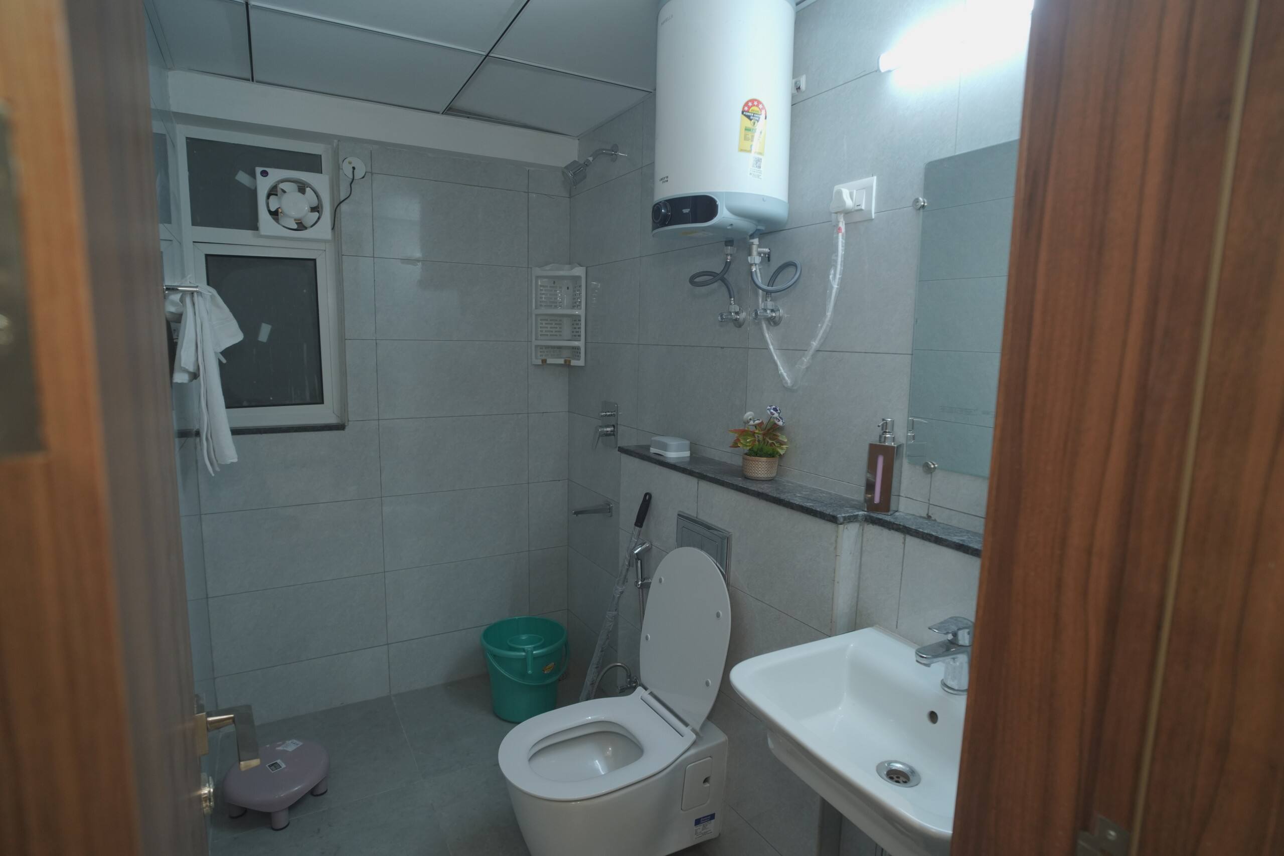 Bathroom with rain shower, geyser, wall-hung WC and vanity basin