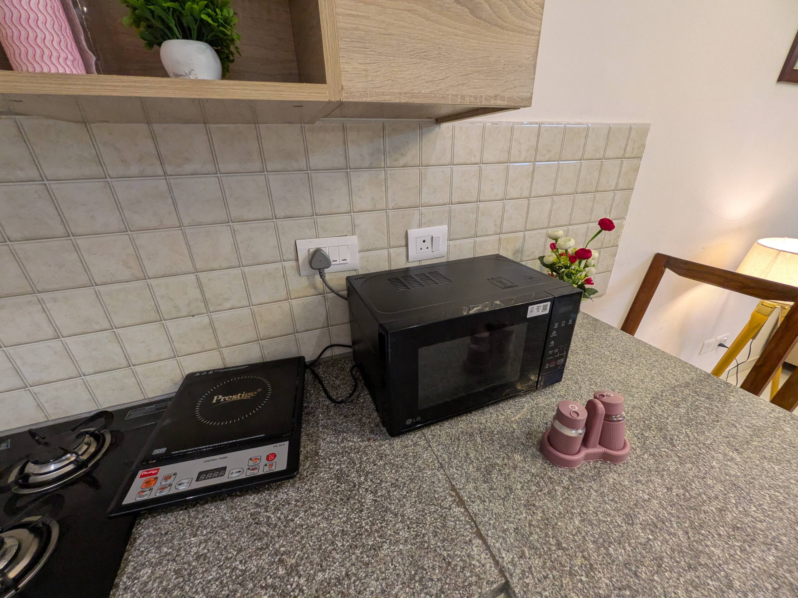 Microwave and induction cooktop on the granite counter