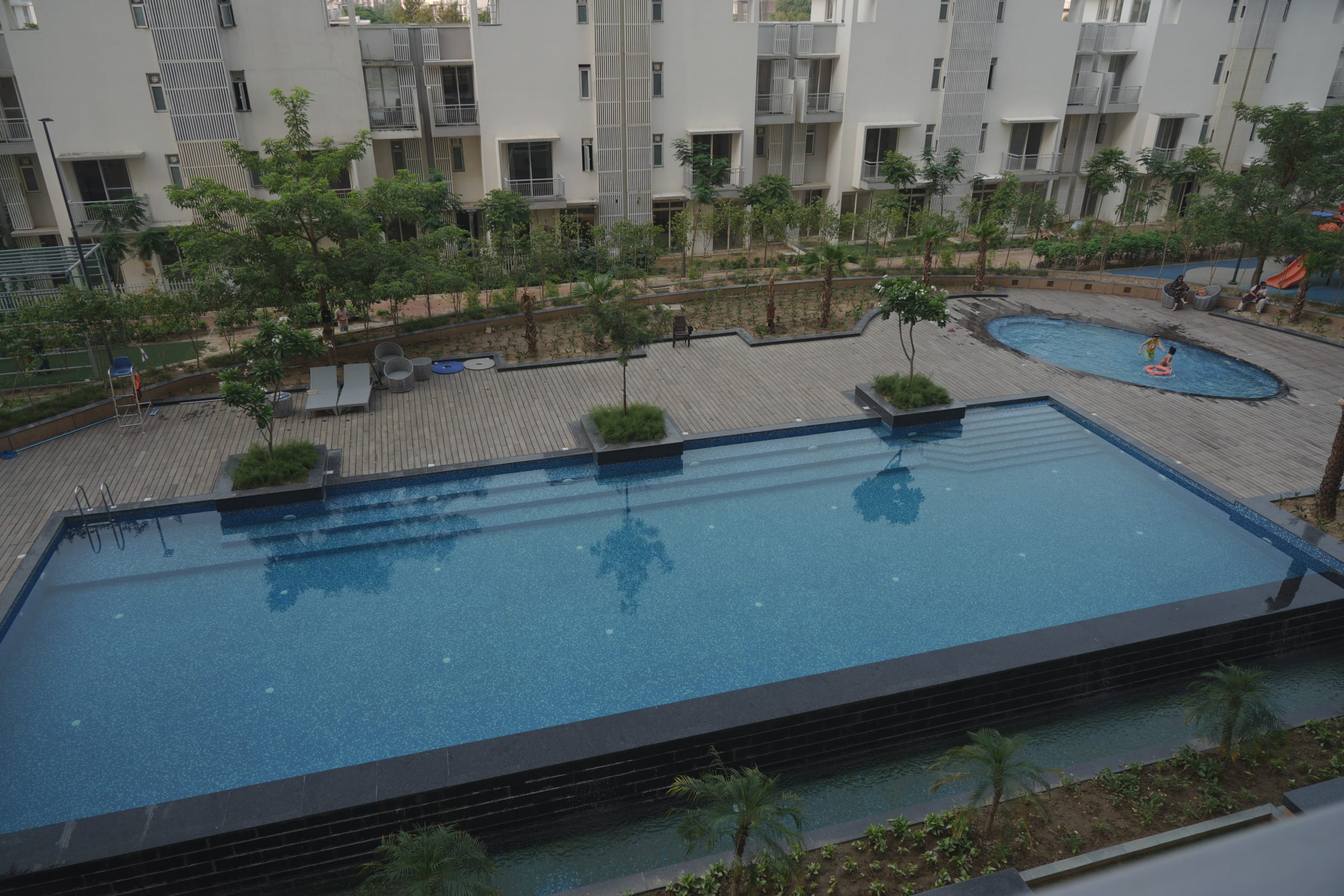 Swimming pool with landscaped deck at Godrej Golf Links