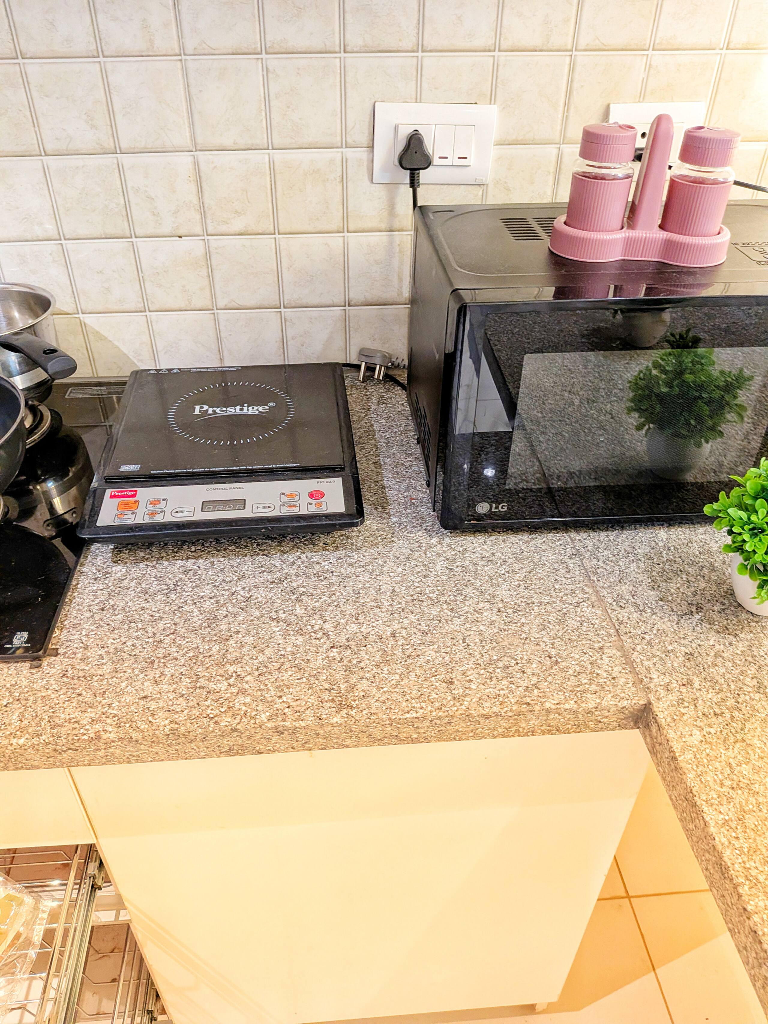 Granite counter with induction cooktop, microwave and storage canisters