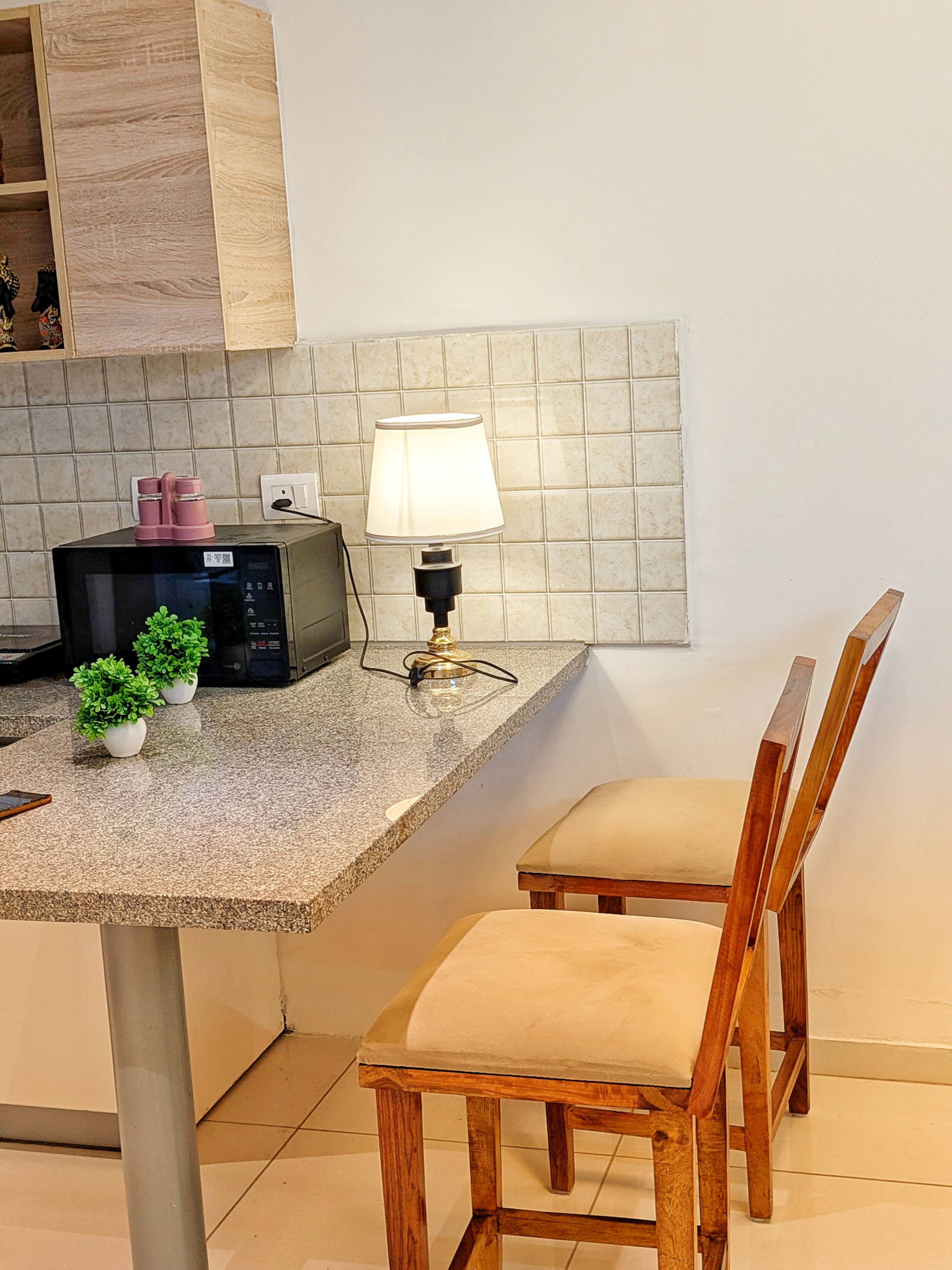 Breakfast bar with microwave, lamp and wooden chairs