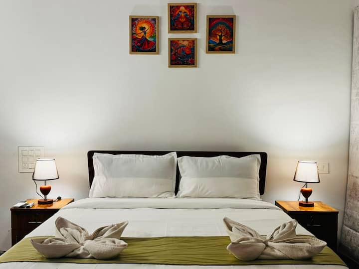 A spacious king-size bedroom with premium bedding, elegant interiors, calming bedside lighting, and a calming atmosphere. Designed for restful sleep and complete comfort after a day exploring North Goa.