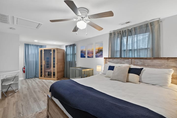 Amplio dormitorio de descanso con detalles en azul costero, cama tamaño king, sauna interior, cuna, área de escritorio y suave luz natural.
