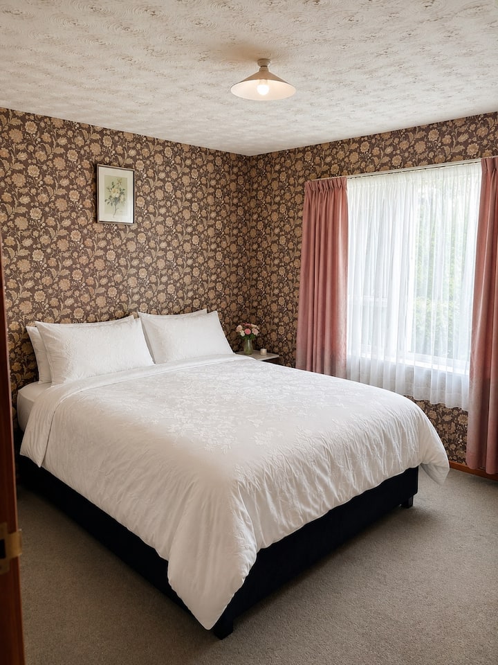 Chambre Queen - Chambre Queen lumineuse et confortable avec une literie confortable, une vue sur le jardin et beaucoup de lumière naturelle.