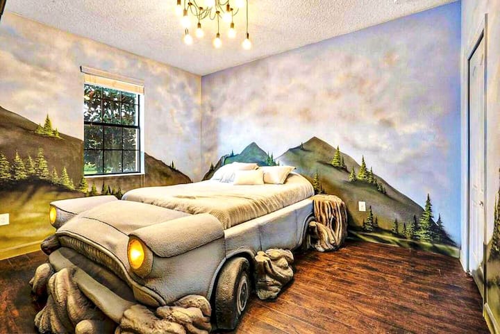 Cloud murals floor to ceiling — and a life-sized Ford Anglia hovering right in the middle of it. Working headlights, real radio. Mind the Whomping Willow. The kids will fight over this one.