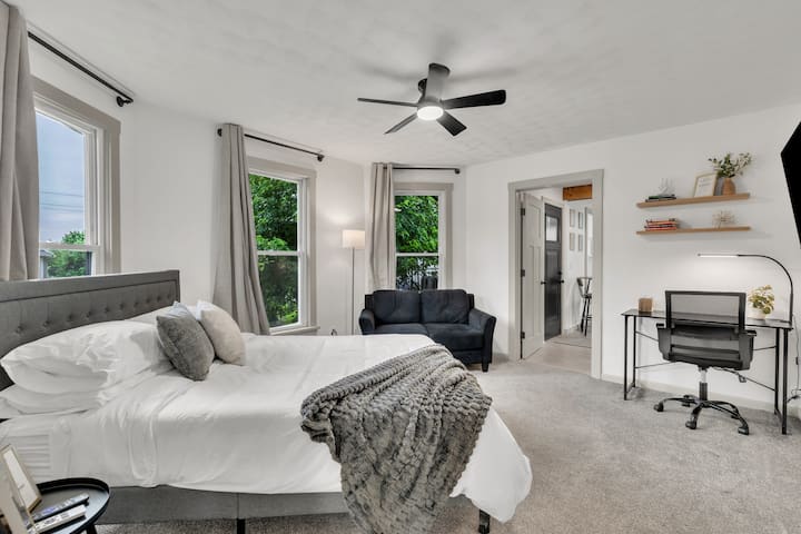 Habitación en el nivel superior con cama tamaño queen, clóset, sofá adicional, estación de trabajo exclusiva y televisión inteligente de 50 pulgadas para streaming.
