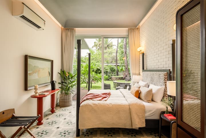 Bright bedroom with a king-size bed, attached ensuite bathroom, and pool access.