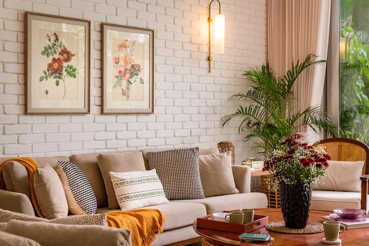 Spacious, air-conditioned living room with comfortable seating, a smart TV, music speaker, an adjoining dining area, and direct access to the private pool.