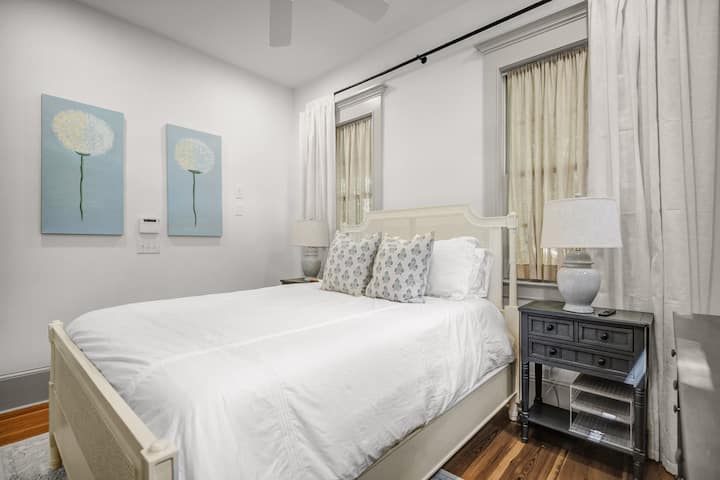 Chambre avec grand lit (queen size) au rez-de-chaussée et une salle de bain complète juste à l'extérieur de la chambre.