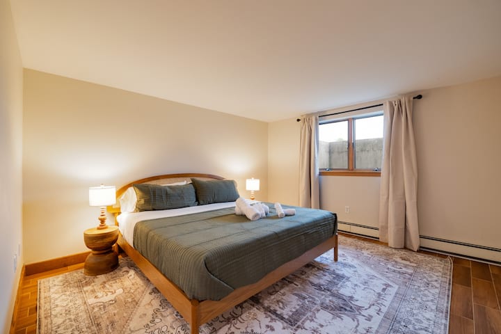 Bright, peaceful bedroom with warm lighting and plenty of space to unwind