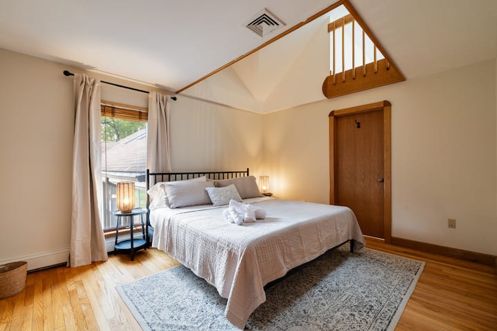 Bright loft-style bedroom with vaulted ceiling and cozy natural light