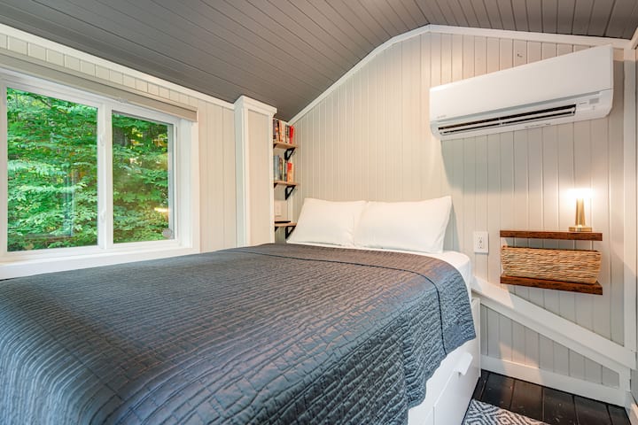 Sleeping loft: a full-size bed, cozy linens, and treetop views.