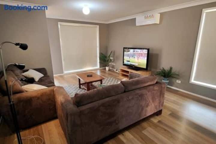 Cozy lounge with plush seating, TV, natural light, and A/C