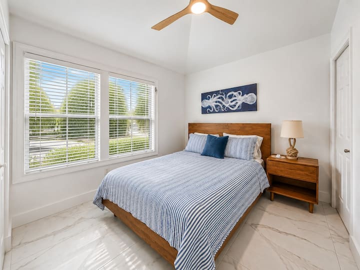 Comfortable second king bedroom with coastal décor, premium bedding, and plenty of natural light.