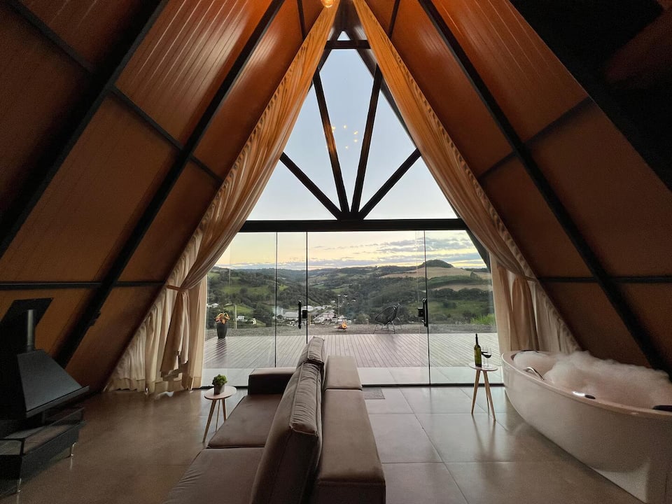 Chalé Refúgio visto de fora, com deck e vista para o horizonte