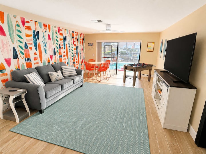 Game room offers queen sofa bed, Smart TV, Xbox One S with wireless controller, foosball table, dining/card table, and several family games