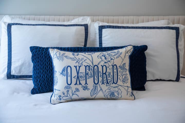 ผ้าปูที่นอนสีขาวสดใส สีกรมท่าสีจาง และหมอน "OXFORD" ที่กระซิบถึงเสน่ห์ของเมืองเล็ก หลบเข้าไปใต้ผ้าคลุมเมื่อค่ำคืนเข้ามา เตียงนอนนี้สร้างมาเพื่อช่วงเช้าที่ช้าและการพักผ่อนอย่างสบายและลึกซึ้ง