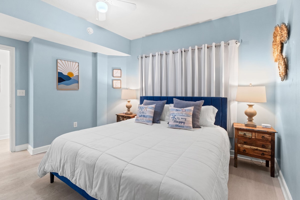Bright coastal-style bedroom with plush king bed