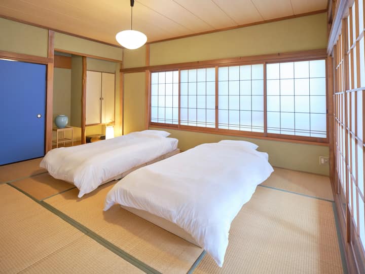 和室には2台のベッド。布団で眠りたい方には3組のムアツ布団のセットがあります。