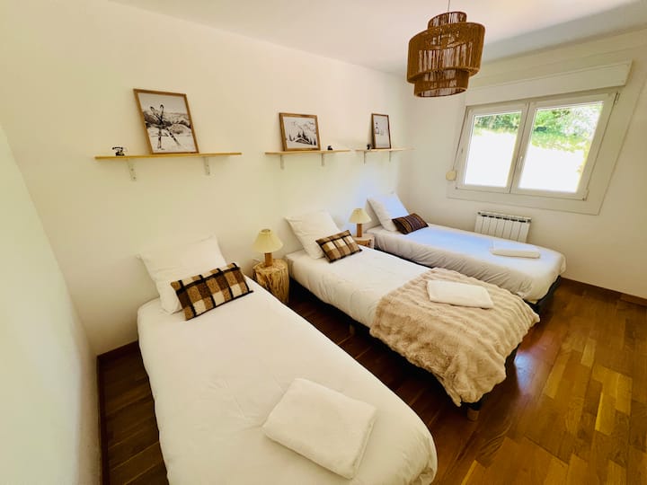 Dhomë magjepsëse në katin përdhes me tre krevate tekë 90 x 200 cm. E gjerë, e ndritshme dhe me hyrje të lehtë, është dhoma ideale për fëmijët, adoleshentët ose miqtë që duan secili hapësirën e vet të gjumit.