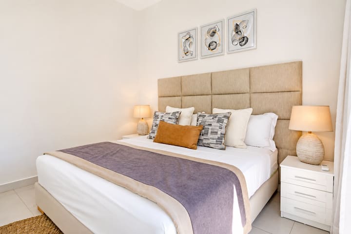 Chambre double avec tête de lit capitonnée, literie de qualité et décoration soignée. Ambiance chaleureuse et reposante.