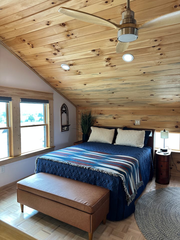 A luxurious bed with an unbeatable view for a relaxing night of deep sleep. TV mounted on the wall across from the bed.