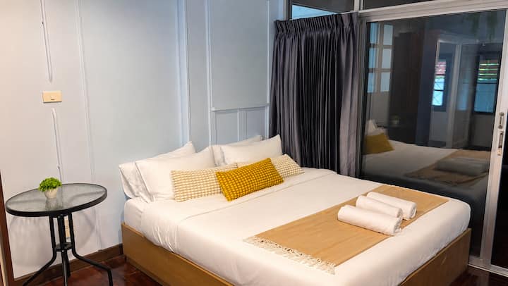Airy bedroom with a queen bed and sliding glass doors.