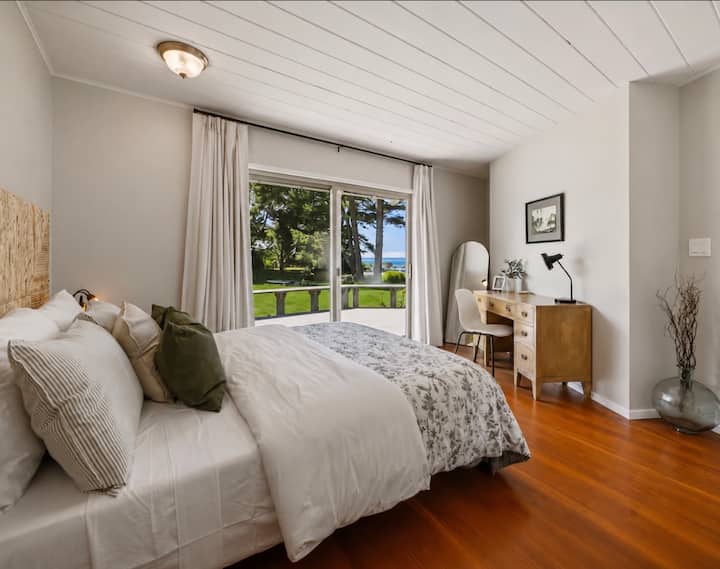 Une chambre paisible avec un grand lit (queen size), un espace de travail dédié, de magnifiques vues sur l'océan et un accès direct à la terrasse.
