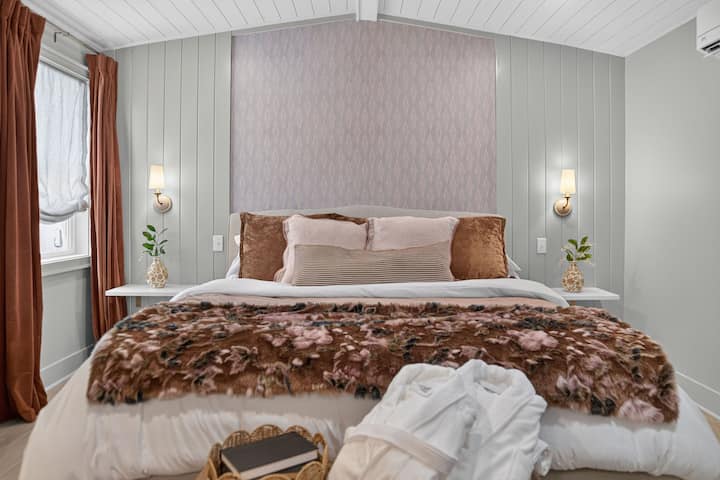 Chambre confortable de style boutique avec une literie somptueuse et des touches chaleureuses de designer