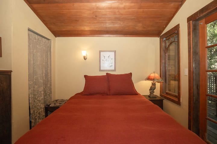 Chambre chaleureuse avec literie rouge et lumière douce de la lampe.