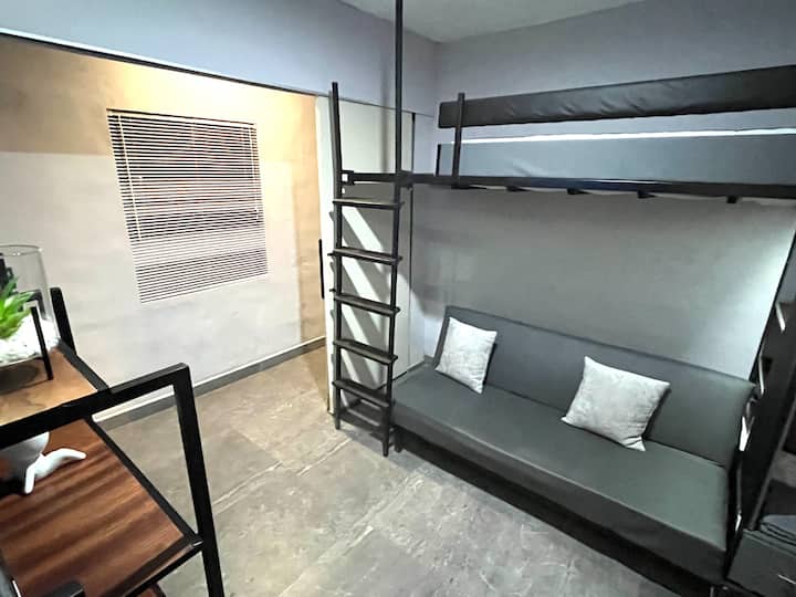 Versatile space that functions as a TV room or a private bedroom thanks to its folding wall. It has air conditioning, TV (IZZI), Netflix, a sofa bed, a loft bed and a bathroom, offering privacy, comfort and flexibility for a comfortable and fun stay.