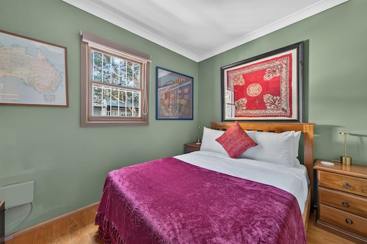Recarga energías en el segundo dormitorio, donde una cama doble y coloridas obras de arte en estilo galería crean un refugio cálido y acogedor.