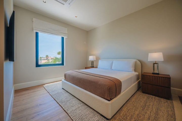 Cozy Bedroom 5 with a comfortable king bed, bedside tables, and a peaceful view outside the window.