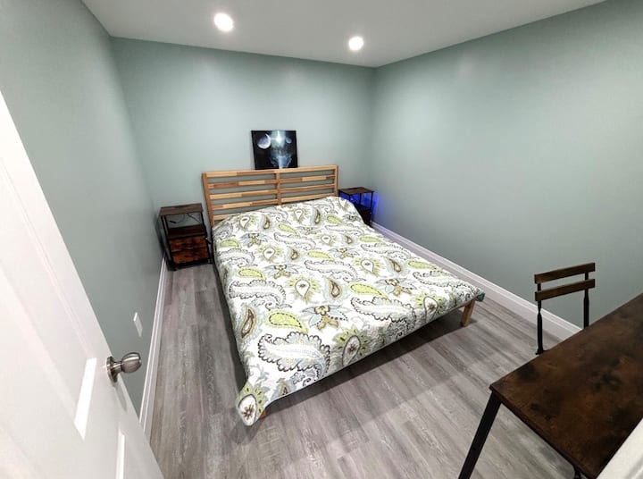 Chambre 4 · Étage supérieur. Une chambre simple et fermée avec un lit, des tables de chevet et une petite surface de travail ou pour les bagages, à l'aménagement épuré et sans encombrement.