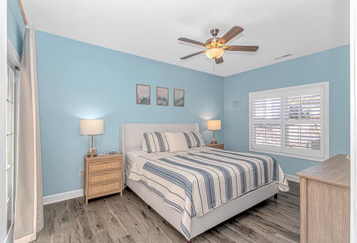 Bright coastal bedroom with plantation shutters and a relaxing vibe