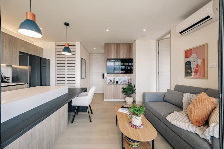 Una sala acogedora y elegante con aire acondicionado que se conecta a la perfección con la cocina y el balcón, perfecta para relajarse después de explorar la ciudad. Cuenta con un televisor de 50 pulgadas y un pequeño sofá cama adecuado para un huésped adicional
