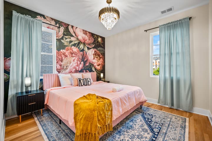 Refúgiate en la espaciosa suite principal con una lujosa cama tamaño king, un espectacular mural floral y un ambiente tranquilo diseñado para noches de descanso.