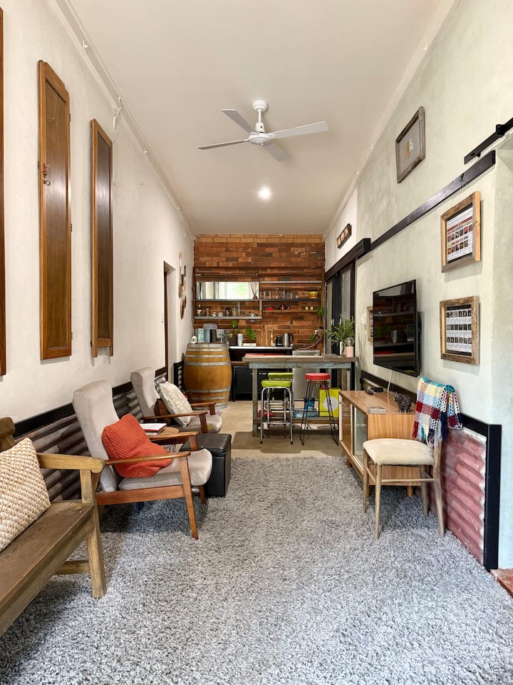 Lounge room area includes a long church pew and two sitting chairs 