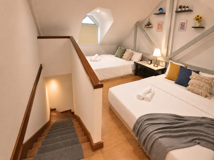 A cozy loft-style bedroom with two queen beds—perfect for friends, families, or a fun group stay.