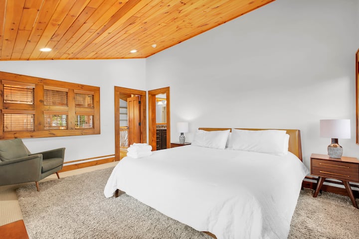 One of two upstairs guest king suites, a quiet retreat with a reading chair and private doors straight to its ensuite bath