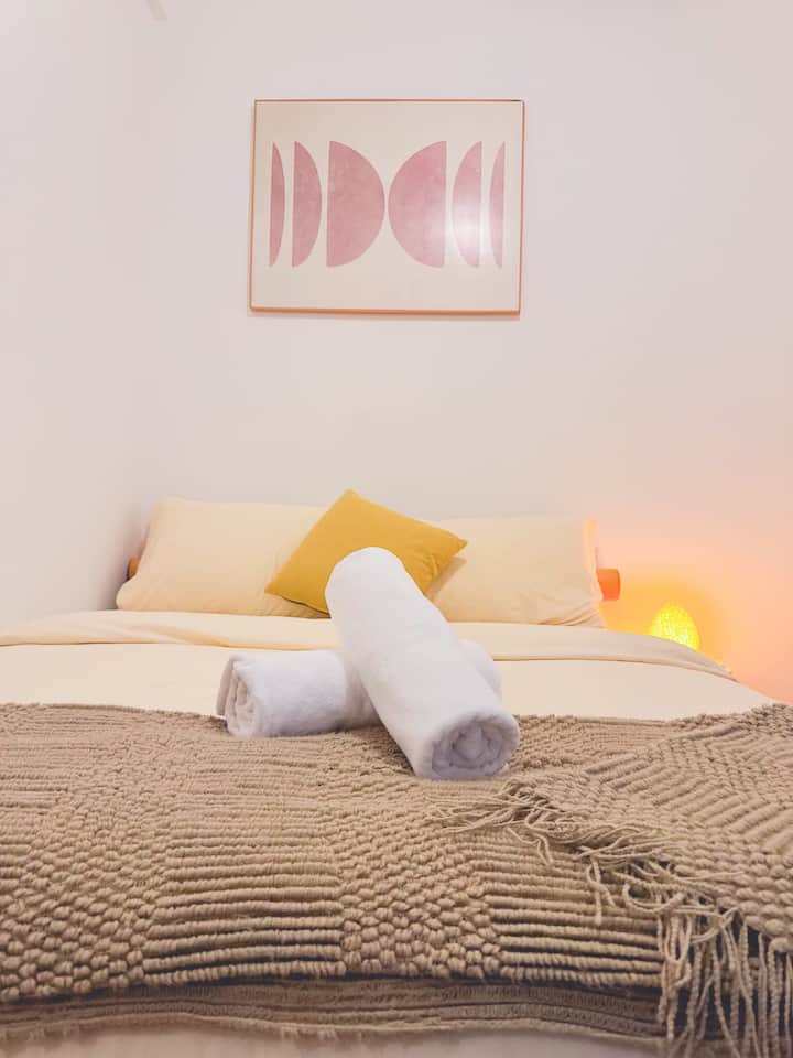 Embrace Japanese-inspired calm. Featuring a low wooden platform bed, soft ambient glow, and plush layered throws, this grounded nook offers a deeply restful, serene escape.