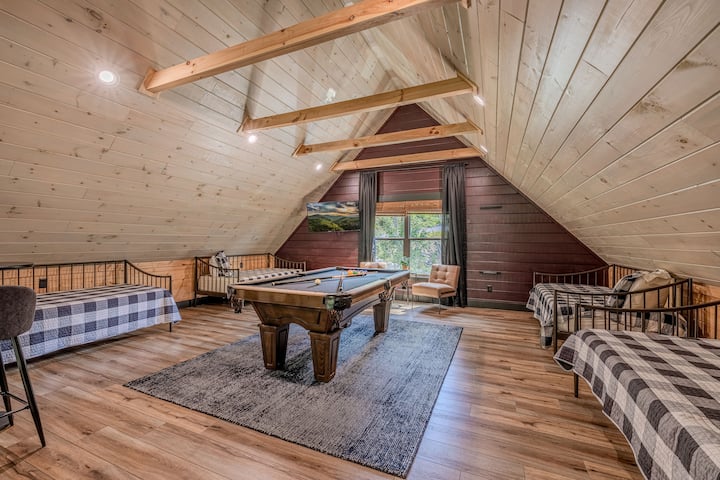 Bedroom 3 is an loft open to the downstairs great room and dining room.  The loft has a full size pool table, 4 twin daybeds, and rustic charm