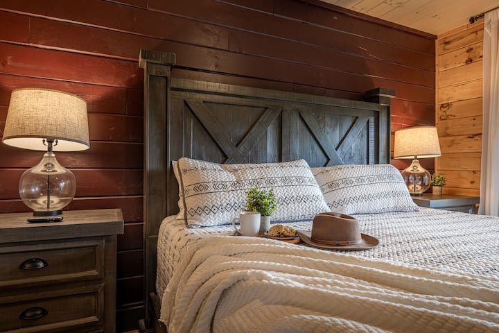 The rustic main floor bedroom has warm lighting and inviting cabin charm