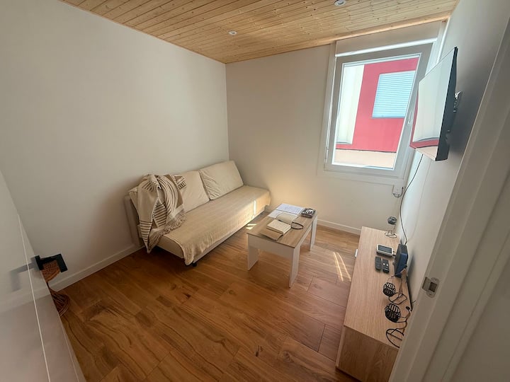 Salón luminoso con sofá cama para 2 huéspedes más y mesa de centro.