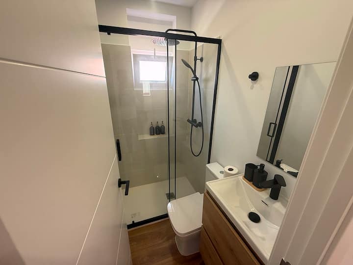 Baño completo con ducha a ras y agua caliente.