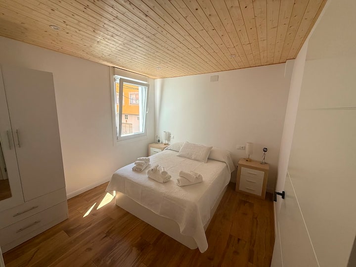 Dormitorio 1 con armario empotrado, perchas y persianas opacas.