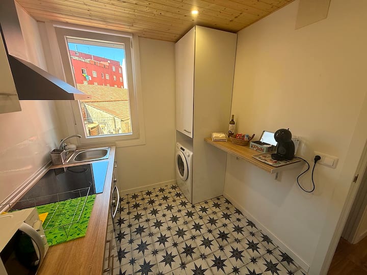 Cocina con lavadora y fregadero, con agua caliente y lo básico para cocinar.