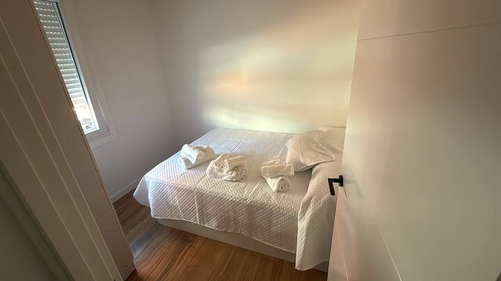 Dormitorio 2 con persianas opacas y techos de madera.